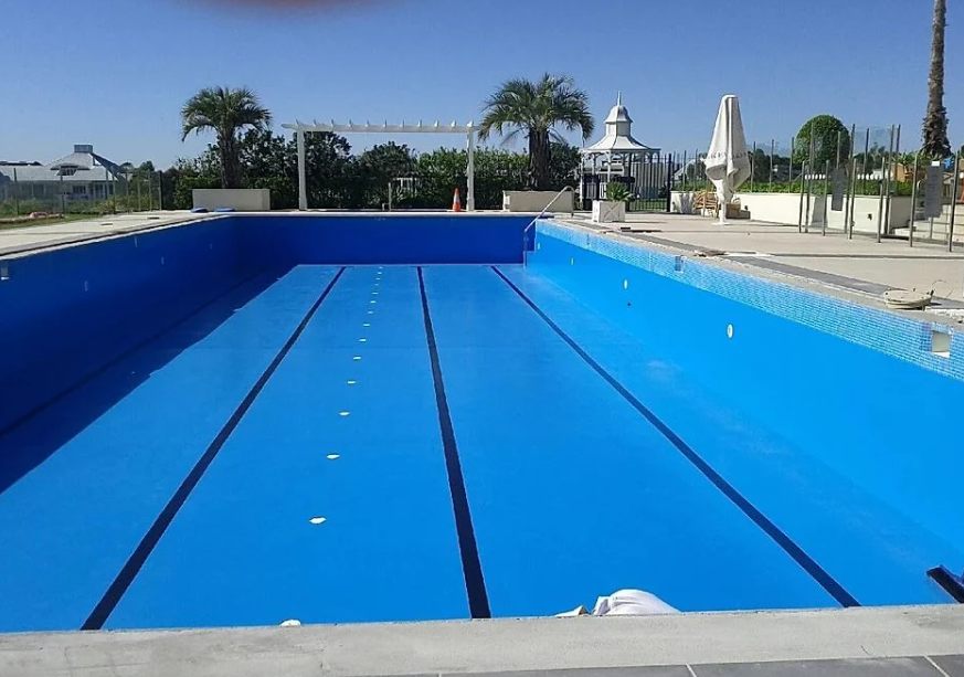 A large swimming pool repainted a fresh, solid blue